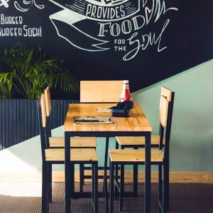 Inviting café interior with wooden chairs and artistic wall design.
